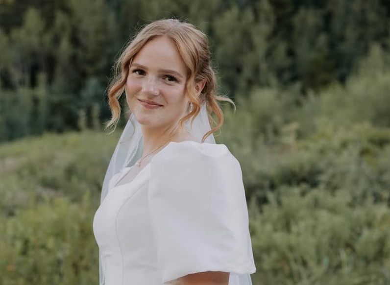 Bride with orange bouquet in meadow